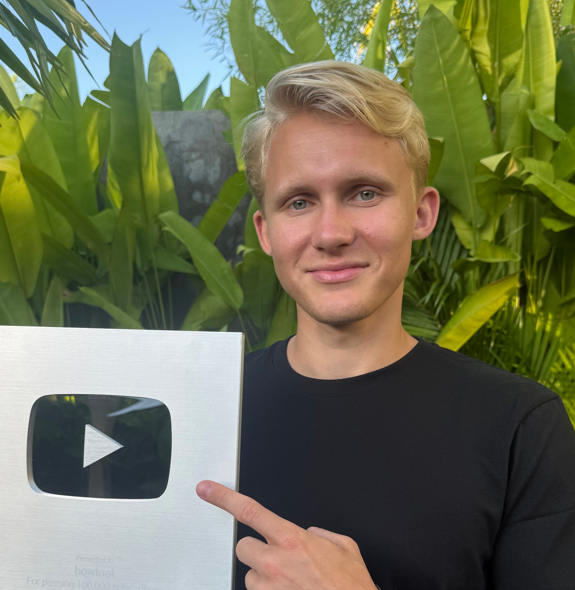 Course founder holding his YouTube 100,000 subscriber Silver Play Button award